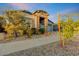 Charming single-story home featuring stone accents, desert landscaping and an attached two-car garage at 16566 W Saguaro Park Ln, Surprise, AZ 85387