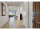 Open and airy hallway with tile flooring, flowing into a bright and spacious living area with natural light at 16566 W Saguaro Park Ln, Surprise, AZ 85387