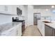 Modern kitchen boasts white cabinetry, granite countertops, stainless steel appliances and breakfast bar at 16566 W Saguaro Park Ln, Surprise, AZ 85387