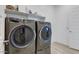 Convenient laundry room featuring modern gray washer and dryer units at 16566 W Saguaro Park Ln, Surprise, AZ 85387
