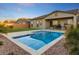 Inviting backyard pool and spa featuring lush landscaping and a covered patio, perfect for relaxation at 16566 W Saguaro Park Ln, Surprise, AZ 85387