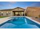 Inviting in-ground pool reflecting the sky, set in a private backyard with a covered patio at 16566 W Saguaro Park Ln, Surprise, AZ 85387