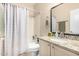 This bathroom has a granite countertop and a tub and shower area with a patterned shower curtain at 17132 E Hillcrest Dr, Fountain Hills, AZ 85268
