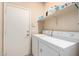 The laundry room features a washer and dryer and shelf for storage in a room with a nearby door at 17132 E Hillcrest Dr, Fountain Hills, AZ 85268