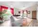 Bright living room features modern furniture, hardwood floors, and large windows with decorative red curtains at 17132 E Hillcrest Dr, Fountain Hills, AZ 85268