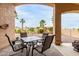This covered patio has an outdoor dining set with views of a backyard and several palm trees at 17132 E Hillcrest Dr, Fountain Hills, AZ 85268