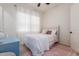Bright bedroom with a soft color scheme, featuring a cozy bed, pink rug, and flowing white curtains at 18422 W Clinton St, Surprise, AZ 85388
