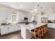 Bright kitchen features white cabinets, stainless steel appliances, dark wood floors, and a quartz countertop island at 18422 W Clinton St, Surprise, AZ 85388