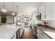 Bright kitchen features white cabinets, stainless steel appliances, dark wood floors, and a quartz countertop island at 18422 W Clinton St, Surprise, AZ 85388