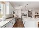 Bright kitchen features white cabinets, stainless steel appliances, dark wood floors, and a quartz countertop island at 18422 W Clinton St, Surprise, AZ 85388