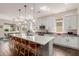 Bright kitchen features white cabinets, stainless steel appliances, dark wood floors, and a quartz countertop island at 18422 W Clinton St, Surprise, AZ 85388
