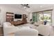 Bright living room featuring contemporary furniture, a ceiling fan, wood flooring, and sliding glass doors at 18422 W Clinton St, Surprise, AZ 85388