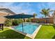 Backyard pool features artificial grass and lush, mature landscaping at 18422 W Clinton St, Surprise, AZ 85388
