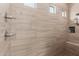 Modern shower with sleek beige tiling, built-in niche, and bench seating for a spa-like experience at 18422 W Clinton St, Surprise, AZ 85388