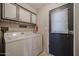 A laundry room with washer, dryer, overhead cabinets, and a door leading to the outside at 205 S Higley Rd # 286, Mesa, AZ 85206