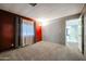 Bright living room with neutral carpet, window with blinds, and a fresh coat of gray and red paint at 205 S Higley Rd # 286, Mesa, AZ 85206