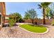 Backyard with desert landscaping, extended patio, and synthetic grass at 2140 S Benton Cir, Mesa, AZ 85209