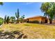 Expansive backyard featuring lush green grass, mature landscaping, and sparkling swimming pool at 2232 E Inglewood St, Mesa, AZ 85213