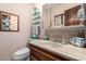 Well-lit half bathroom featuring a tiled backsplash, vanity sink, and coordinating fixtures at 2232 E Inglewood St, Mesa, AZ 85213
