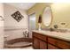 Bright bathroom featuring a bathtub with brown tile accents and a wooden vanity with granite countertops at 2232 E Inglewood St, Mesa, AZ 85213