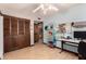 Cozy bedroom with wood-look floors, light blue walls, closet with wooden folding doors, and a ceiling fan at 2232 E Inglewood St, Mesa, AZ 85213