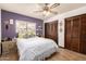 Comfortable bedroom featuring a decorative ceiling fan, accent wall, and wood flooring at 2232 E Inglewood St, Mesa, AZ 85213