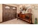 Foyer showcasing a decorative wood table, mirror, artwork, tiled floor, and double front door for a stylish entrance at 2232 E Inglewood St, Mesa, AZ 85213