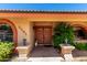 A beautiful front entryway featuring double doors, decorative lanterns, and lush landscaping with a 'Welcome' mat at 2232 E Inglewood St, Mesa, AZ 85213