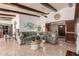 Spacious living room with beamed ceilings and tile flooring, seamlessly connecting to the kitchen area at 2232 E Inglewood St, Mesa, AZ 85213