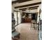 Open-concept living space with beamed ceilings, tile flooring, and barstool seating at 2232 E Inglewood St, Mesa, AZ 85213