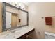 Bathroom features a large mirror and vanity with a sink, plus a toilet and shower in the background at 2455 E Broadway Rd # 68, Mesa, AZ 85204