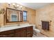 Bathroom with wood cabinets, framed mirror, vanity lighting, and neutral paint at 2455 E Broadway Rd # 68, Mesa, AZ 85204