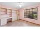Bright bedroom featuring a window, built-in shelves and desk, and neutral tile flooring at 2455 E Broadway Rd # 68, Mesa, AZ 85204