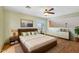 A spacious bedroom with a ceiling fan, wood floors, and a large bed at 2455 E Broadway Rd # 68, Mesa, AZ 85204