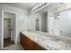 Bathroom featuring a granite vanity top and a walk-in closet at 24709 N 75Th Way, Scottsdale, AZ 85255