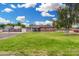 Charming single-story home with a well-manicured lawn, mature trees, and a welcoming facade under a bright sky at 25615 S Lemon Ave, Queen Creek, AZ 85142