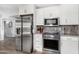 Well-lit kitchen featuring stainless steel appliances, white cabinetry, and ample counter space at 25615 S Lemon Ave, Queen Creek, AZ 85142
