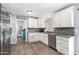 Bright kitchen featuring white cabinets, stainless steel appliances, mosaic backsplash, and wood-look floors at 25615 S Lemon Ave, Queen Creek, AZ 85142
