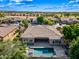 Aerial view of a home with a sparkling pool, lush landscaping, and desert neighborhood at 2565 N 141St Ln, Goodyear, AZ 85395
