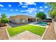 Inviting backyard featuring a sparkling pool, lush lawn, and a covered patio for relaxing or entertaining at 2565 N 141St Ln, Goodyear, AZ 85395