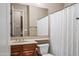Neat bathroom featuring a modern vanity, framed mirror, and shower with white curtain, offering a functional design at 2565 N 141St Ln, Goodyear, AZ 85395