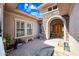 Private courtyard features a stone archway, water feature, and tiled flooring, creating a welcoming entrance at 2565 N 141St Ln, Goodyear, AZ 85395