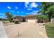Charming home with manicured desert landscaping and a brick driveway leading to an attached three-car garage at 2565 N 141St Ln, Goodyear, AZ 85395