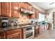 Kitchen featuring stainless steel stove, tile backsplash, range hood, and custom cabinets at 2565 N 141St Ln, Goodyear, AZ 85395