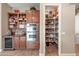 Kitchen with built-in double ovens, wine fridge, custom cabinets, and walk-in pantry at 2565 N 141St Ln, Goodyear, AZ 85395