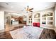 Bright, open-concept living room flows into kitchen, featuring hardwood floors and built-in shelving for modern appeal at 2565 N 141St Ln, Goodyear, AZ 85395