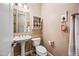 Stylish powder room with pedestal sink, decorative mirror and fixtures, creating an elegant and functional space at 2565 N 141St Ln, Goodyear, AZ 85395