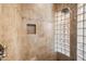 Walk-in shower features neutral tile, a glass block wall and shower niche at 2565 N 141St Ln, Goodyear, AZ 85395