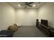 Versatile basement area with neutral carpet, ceiling fan, and TV, offering flexible living space at 2727 N Acacia Way, Buckeye, AZ 85396