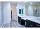Bright bathroom featuring double sinks, a vanity, and a separate glass-enclosed shower at 2727 N Acacia Way, Buckeye, AZ 85396